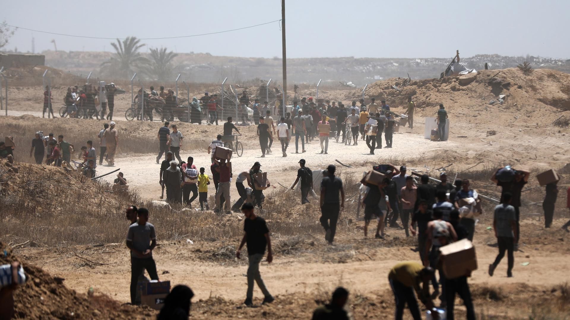 29 May 2025, Palestinian Territories, Bureij: Palestinians walk with aid supplies which they received from the US-backed Gaza Humanitarian Foundation, in Al-Bureij. Photo: Moiz Salhi/APA Images via ZUMA Press Wire/dpa