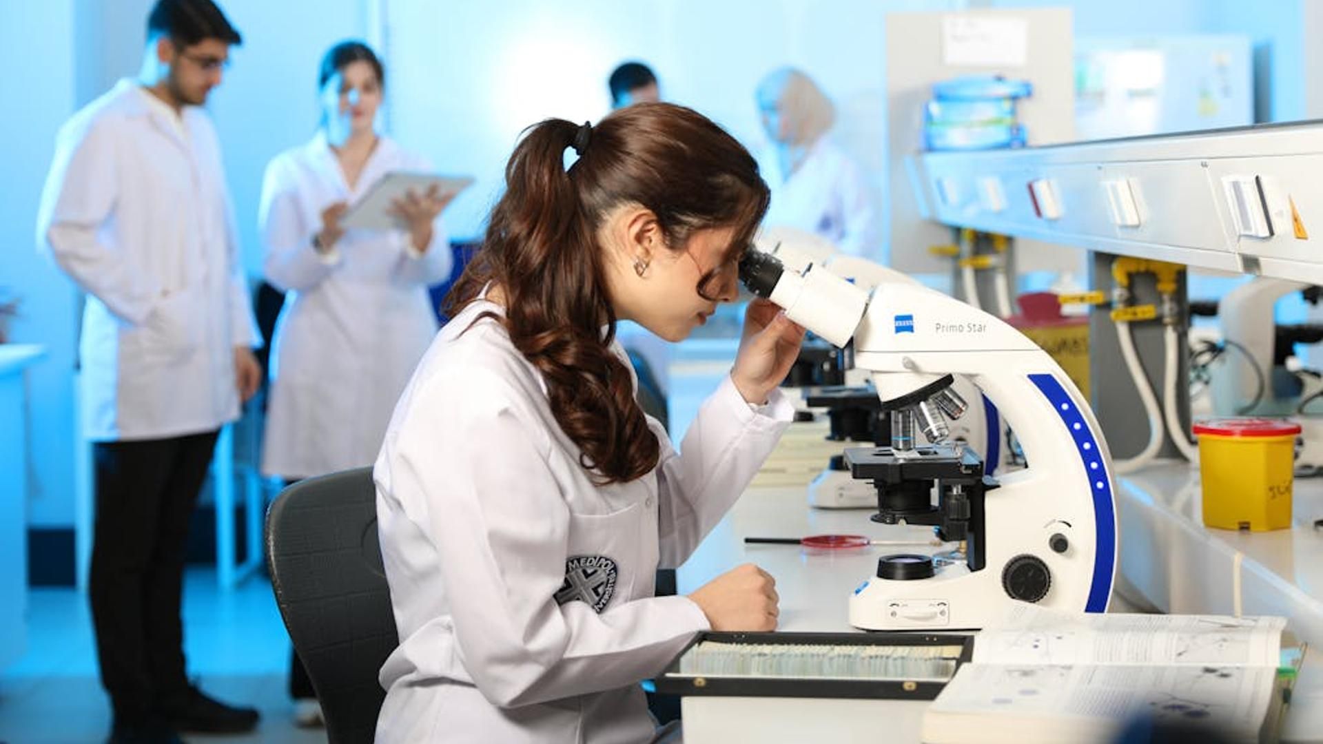 Científica usando un microscopio en un laboratorio