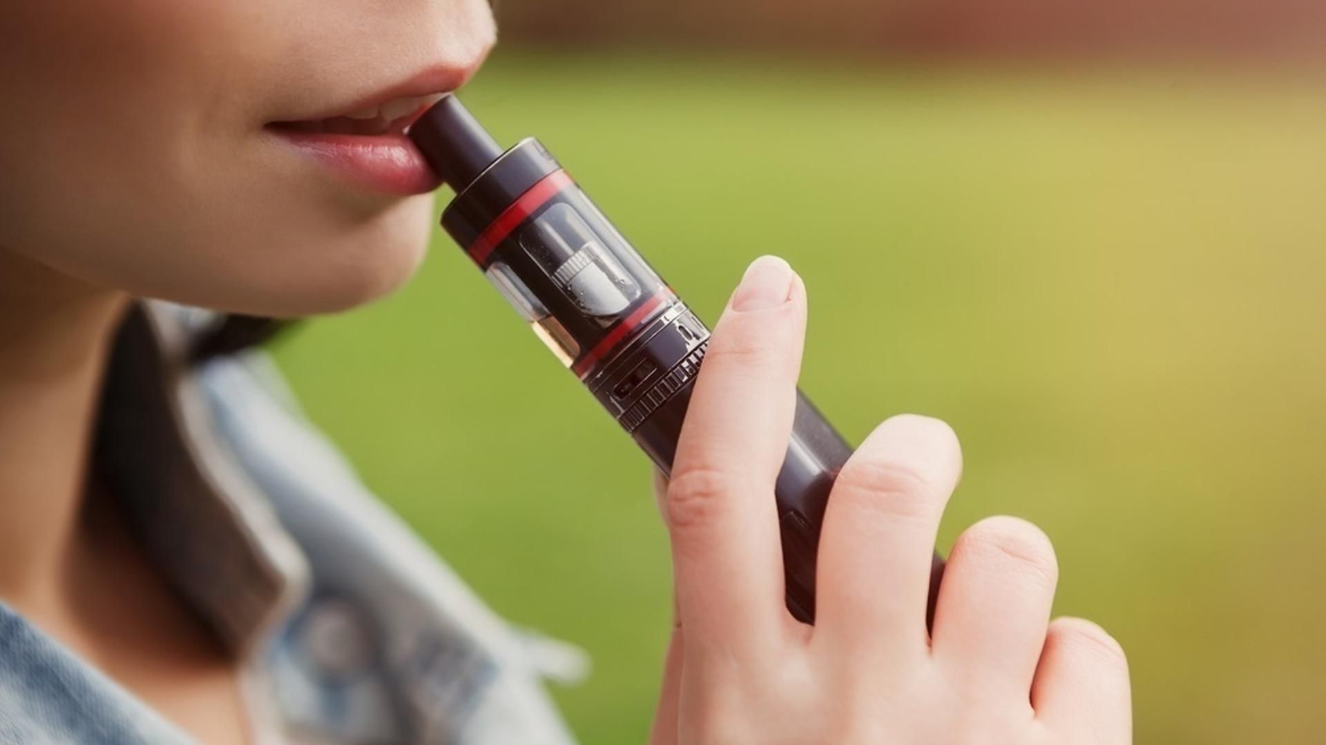 Una mujer utiliza un vapeador Una mujer utiliza un vapeador