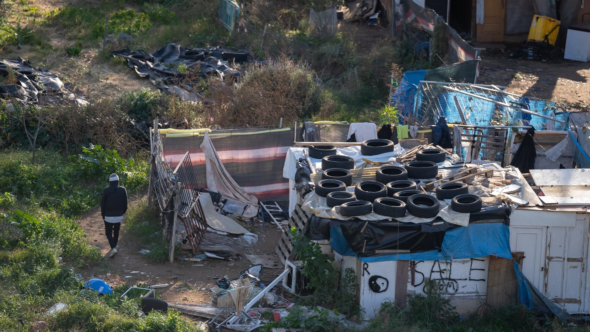 Archivo - Una persona camina entre las barracas del barrio de Vallcarca i els Penitents, a 20 de diciembre de 2024, en Barcelona, Catalunya (España).