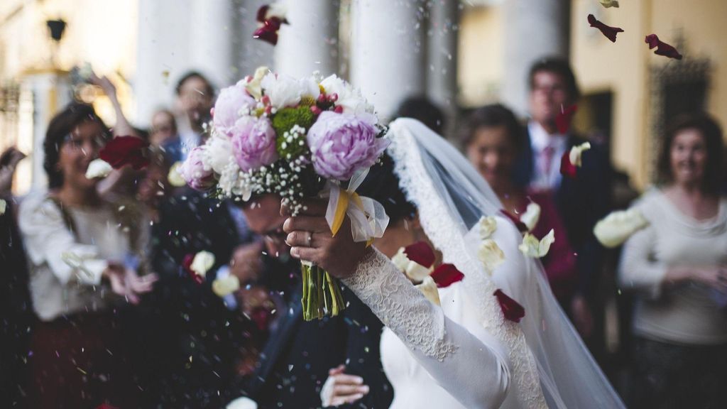 Los invitados tiran flores y arroz a una pareja que acaba de casarse