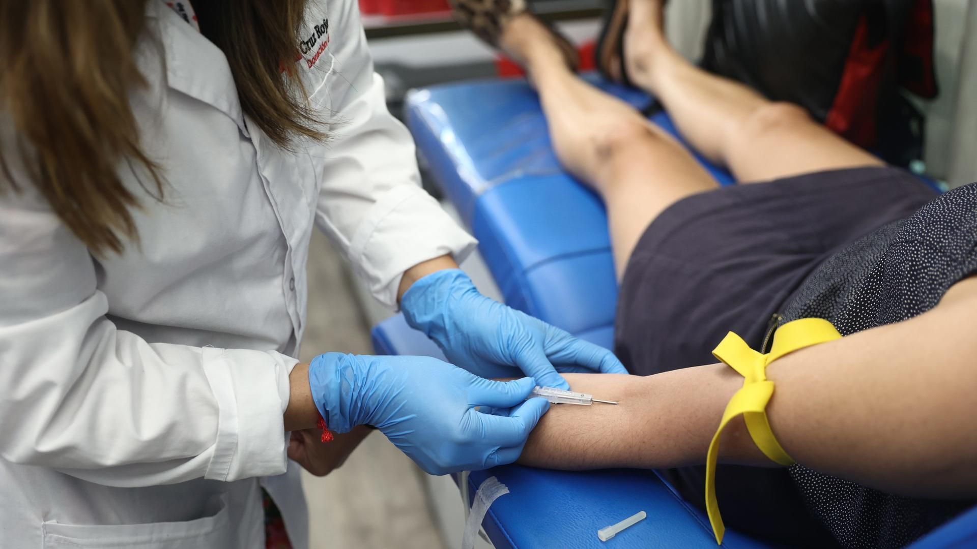 Archivo - Una persona dona sangre durante el  Día Mundial del Donante de Sangre