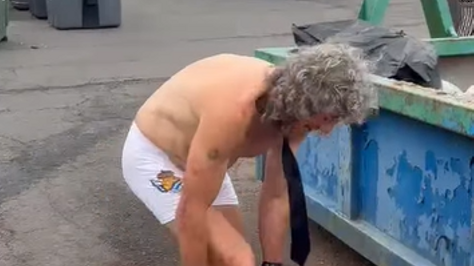 Momento en el que el operario se queda en calzoncillos y tira su ropa de trabajo a un container
