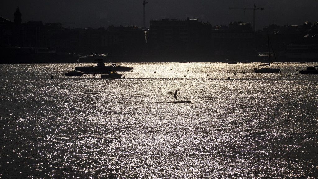 Un hombre practica paddle surf a primera hora del día en la bahía de La Concha, San Sebastián