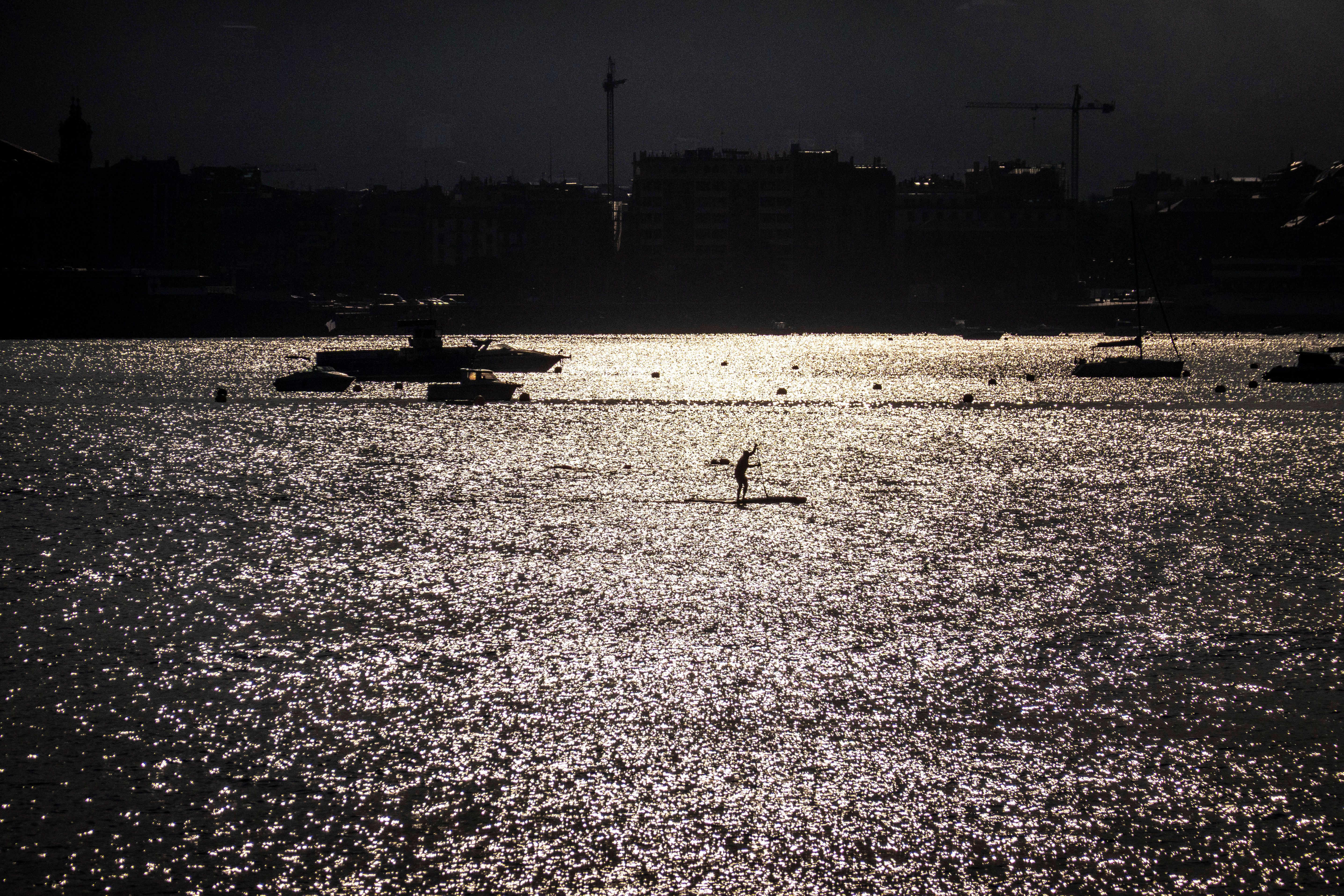 Un hombre practica paddle surf a primera hora del día en la bahía de La Concha, San Sebastián Un hombre practica paddle surf a primera hora del día en la bahía de La Concha, San Sebastián