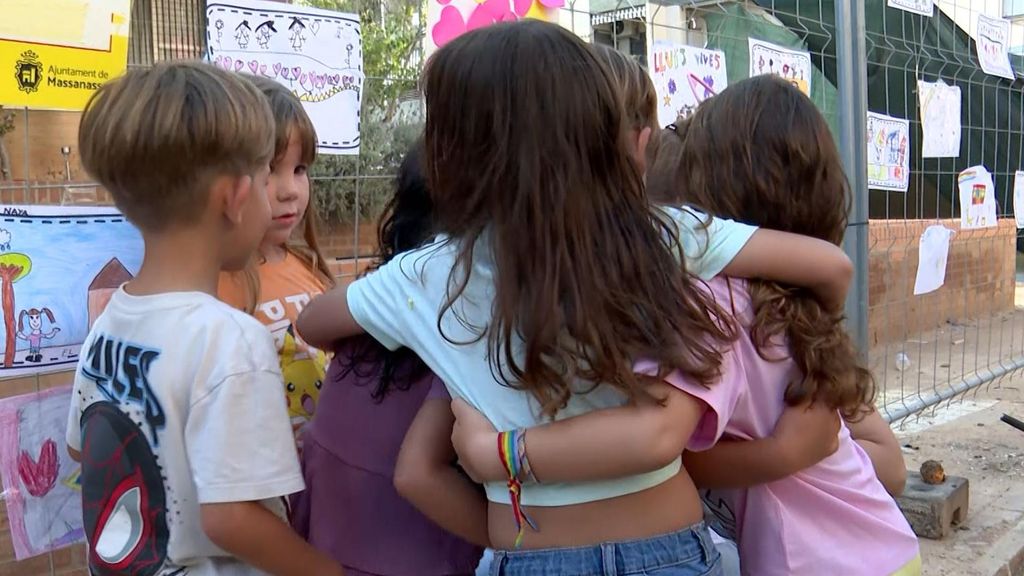 Los niños se abrazan junto al colegio arrasado