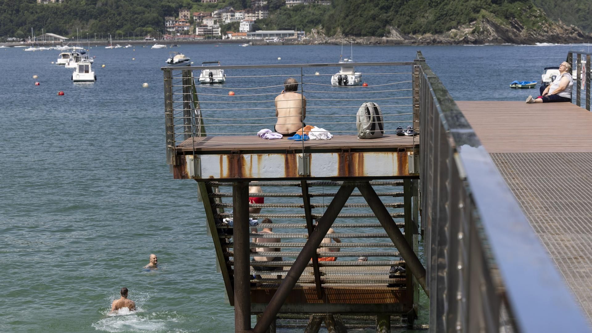 Varias personas disfrutan del buen tiempo en el Náutico de San Sebastián.