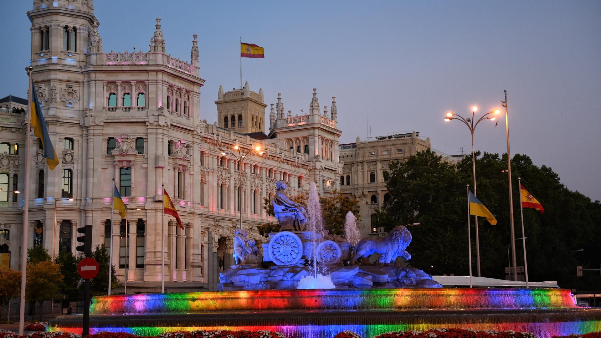 Vista de la fuente y el Palacio de Cibeles con los colores de la bandera LGTBI