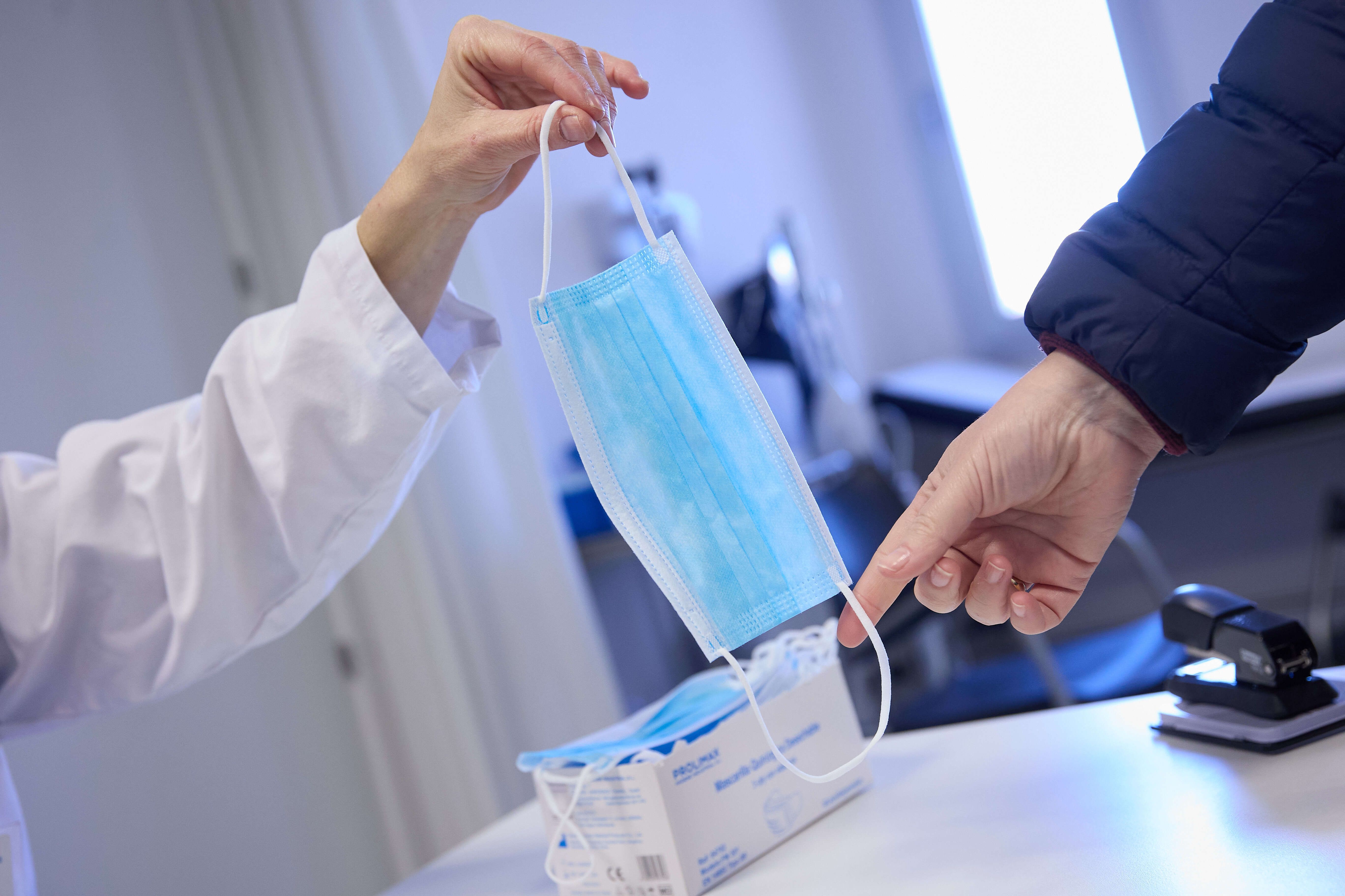 Doctora ofreciendo una mascarilla a un paciente