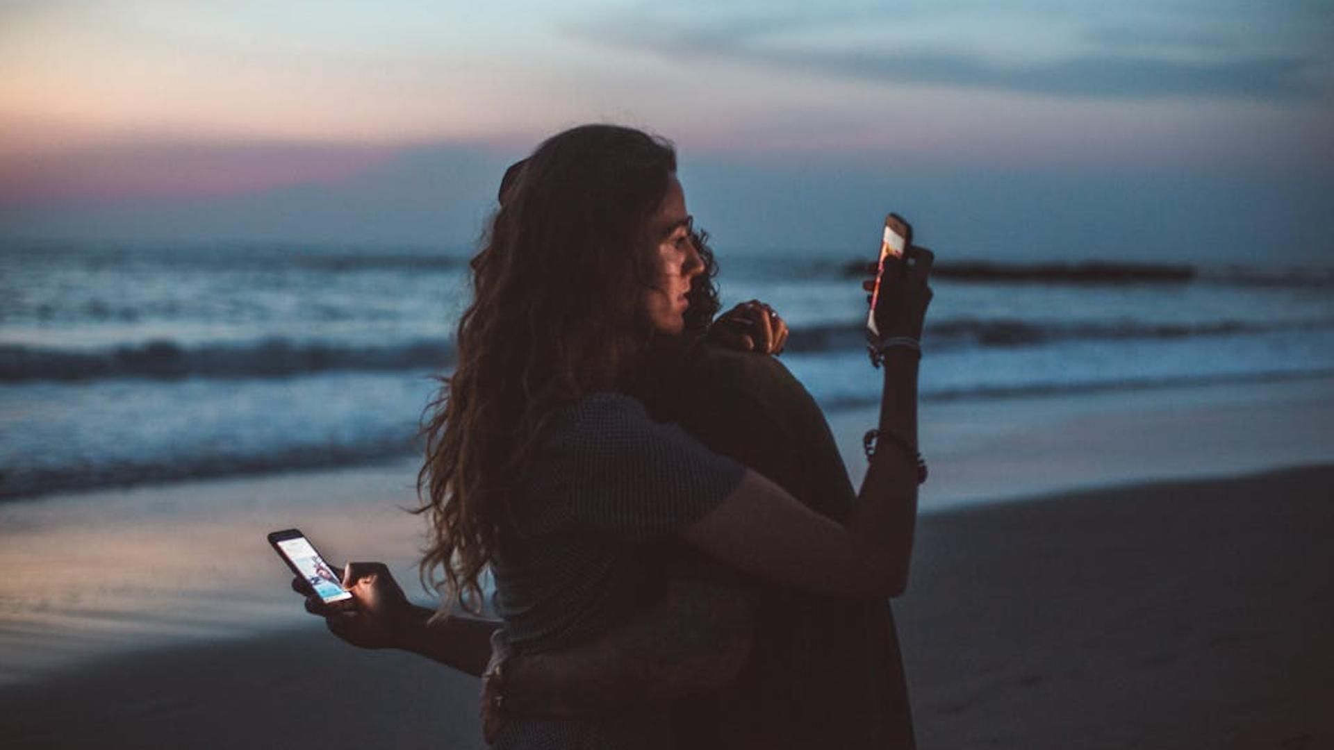 Dos personas mirando sus móviles Dos personas mirando sus móviles