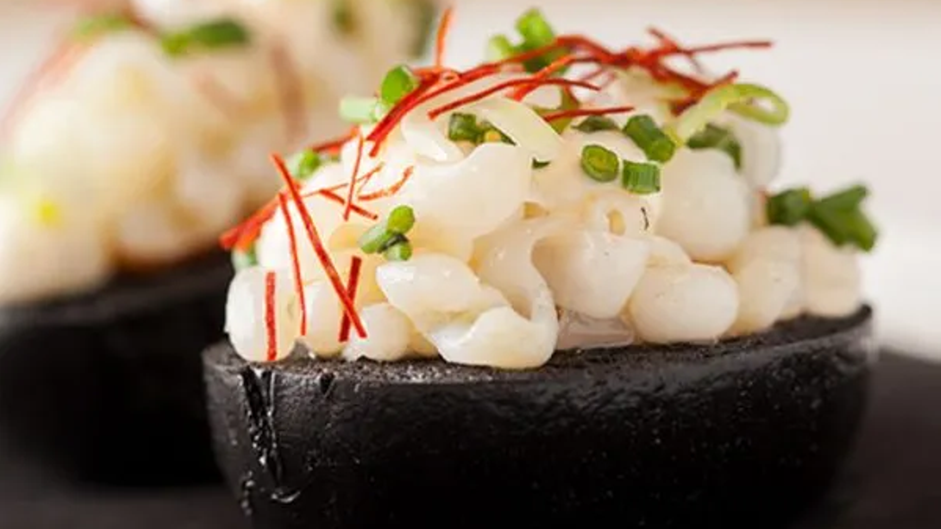 El bollo de tinta con calamar y guiso de oreja