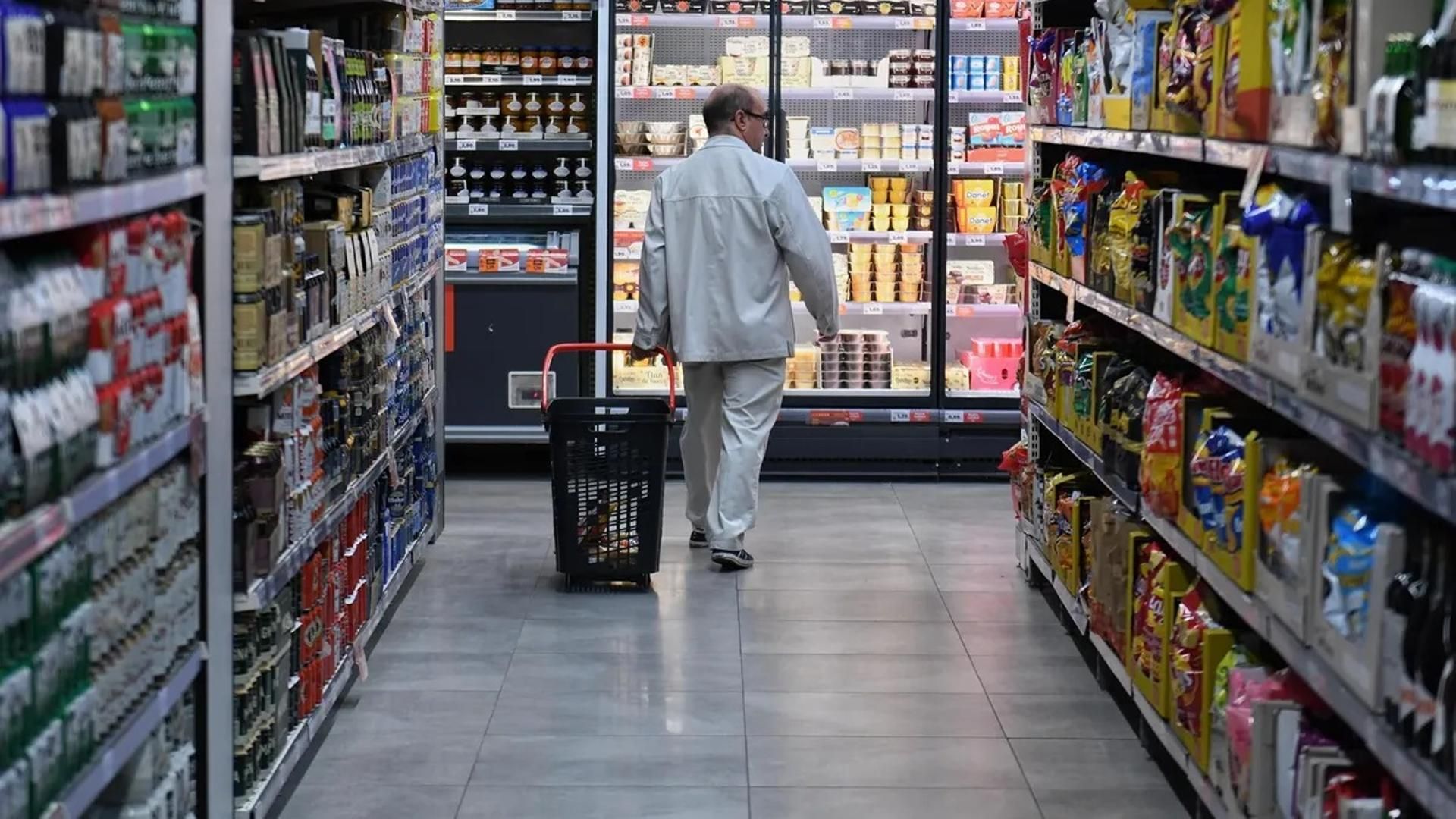 Una persona haciendo la compra en un supermercado tradicional
