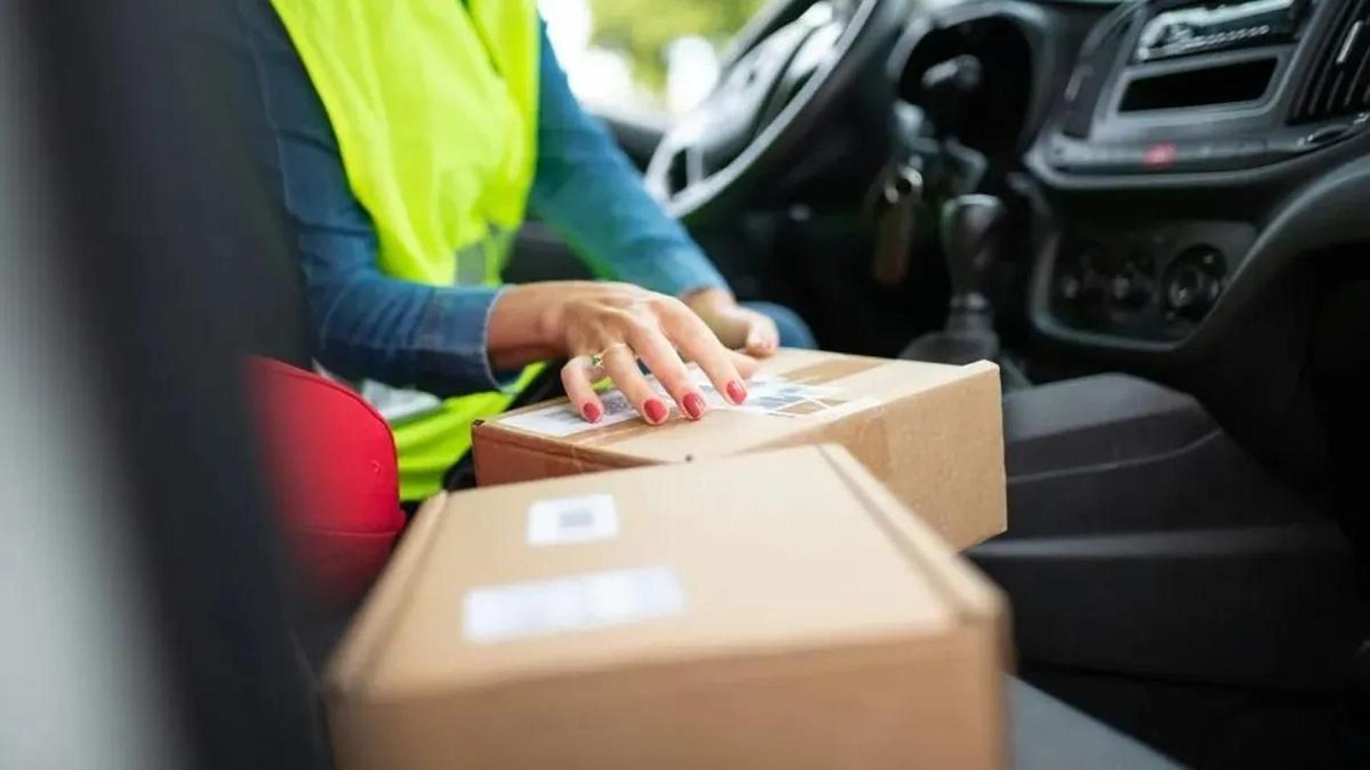 Una trabajadora prepara unos paquetes para entregarlos Una trabajadora prepara unos paquetes para entregarlos
