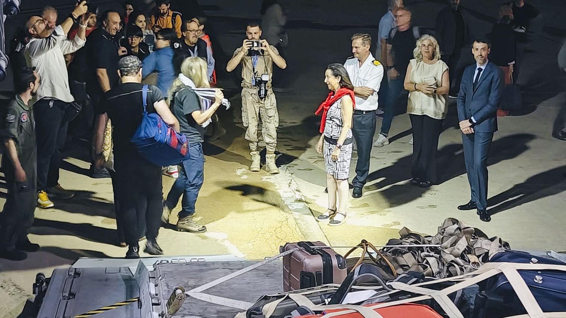 La ministra española de Defensa, Margarita Robles (4d), recibe en la base militar de Torrejón de Ardoz (Madrid) a los primeros españoles evacuados de Israel