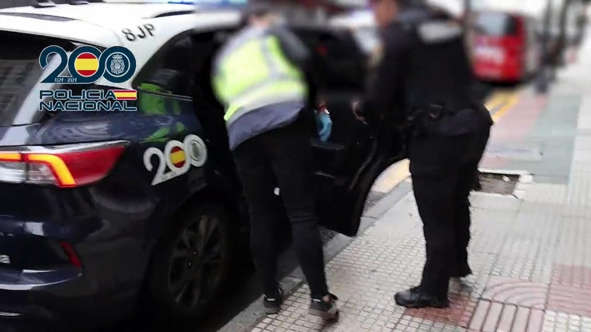 Agentes de la Policía Nacional introducen en un coche policial a un detenido acusado de explotación sexual