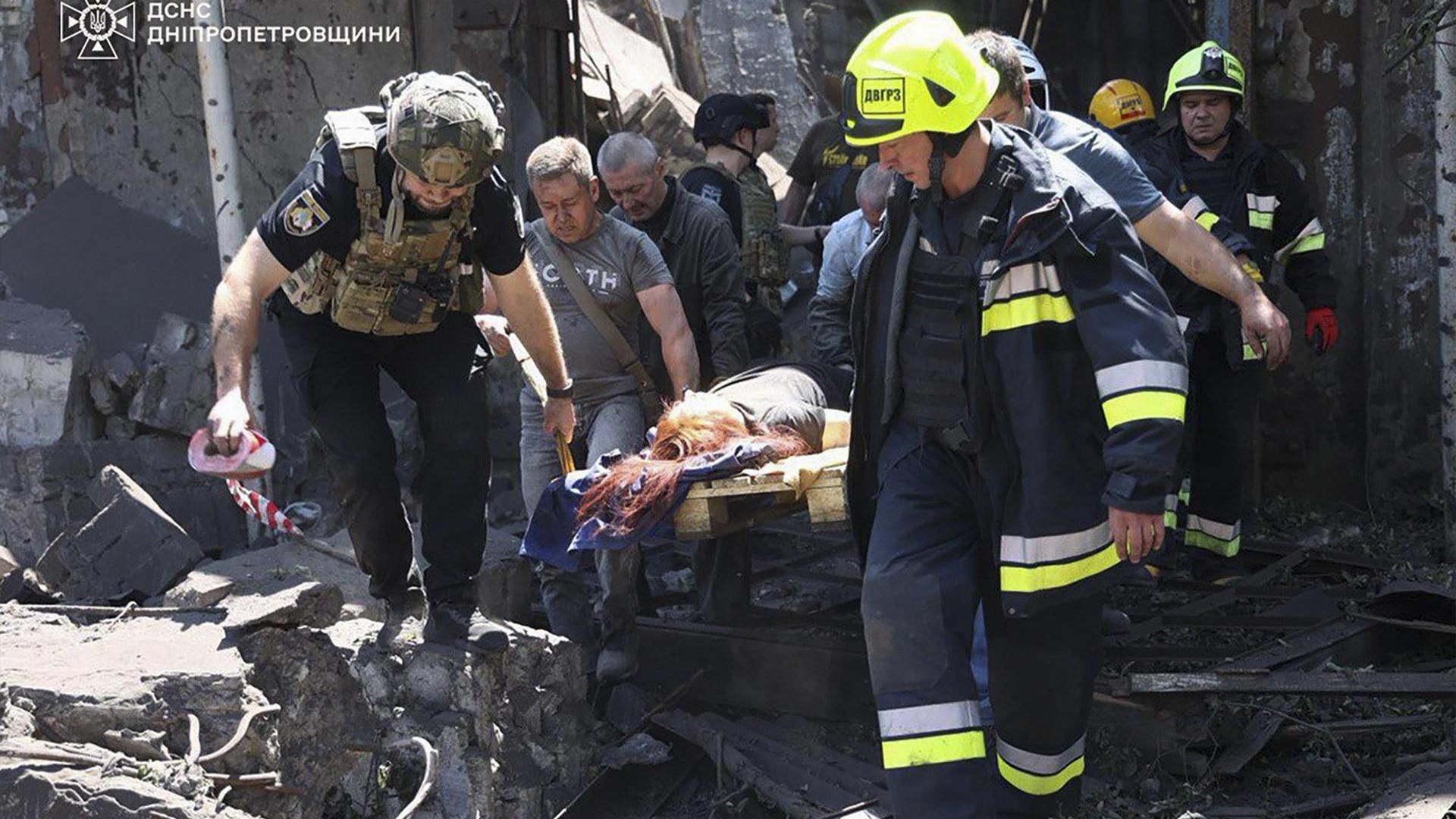 Rescatistas trasladan a heridos alcanzados por las bombas rusas en Dnipró