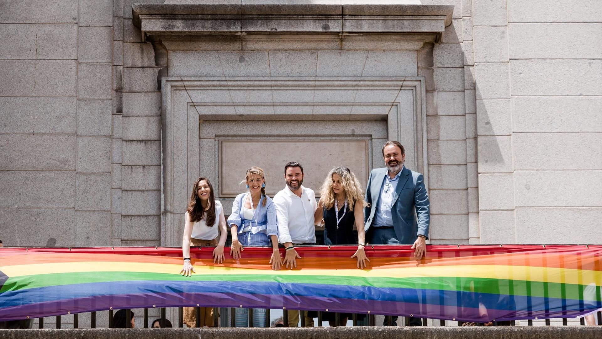 Yolanda Díaz cuelga la bandera LGTBI en la fachada del Ministerio junto a representantes del colectivo