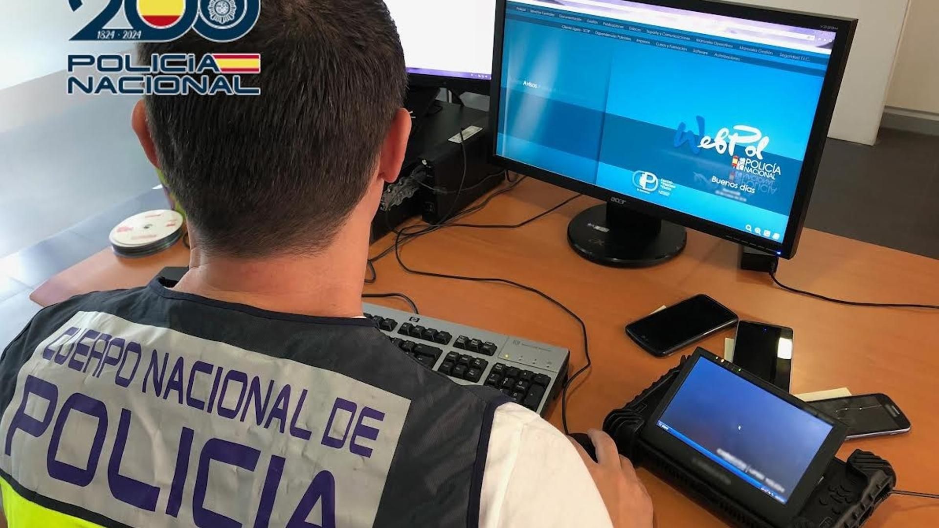 Archivo - Un agente de la Policía frente a un ordenador