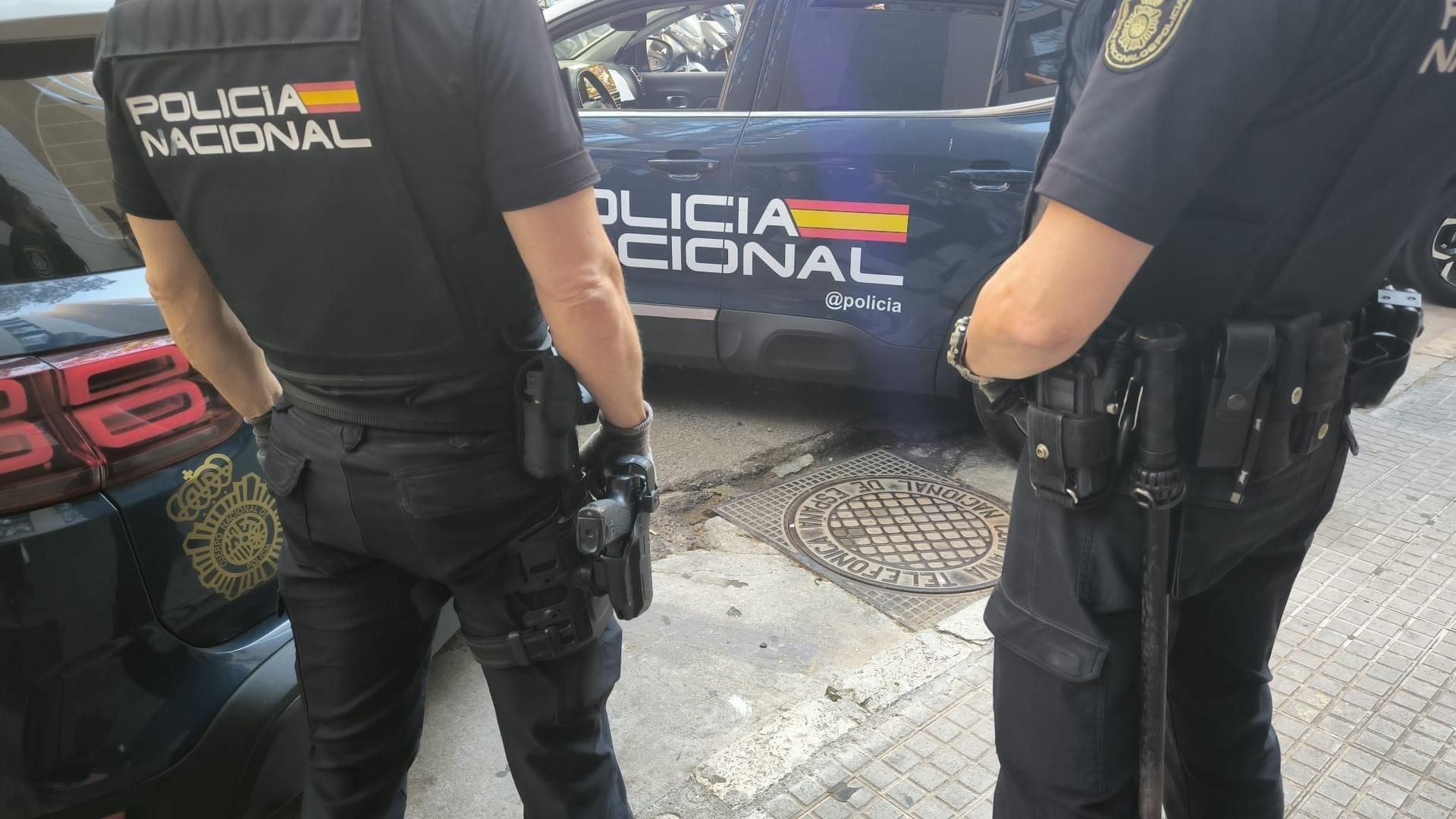 Agentes de la Policía Nacional frente a un vehículo policial
