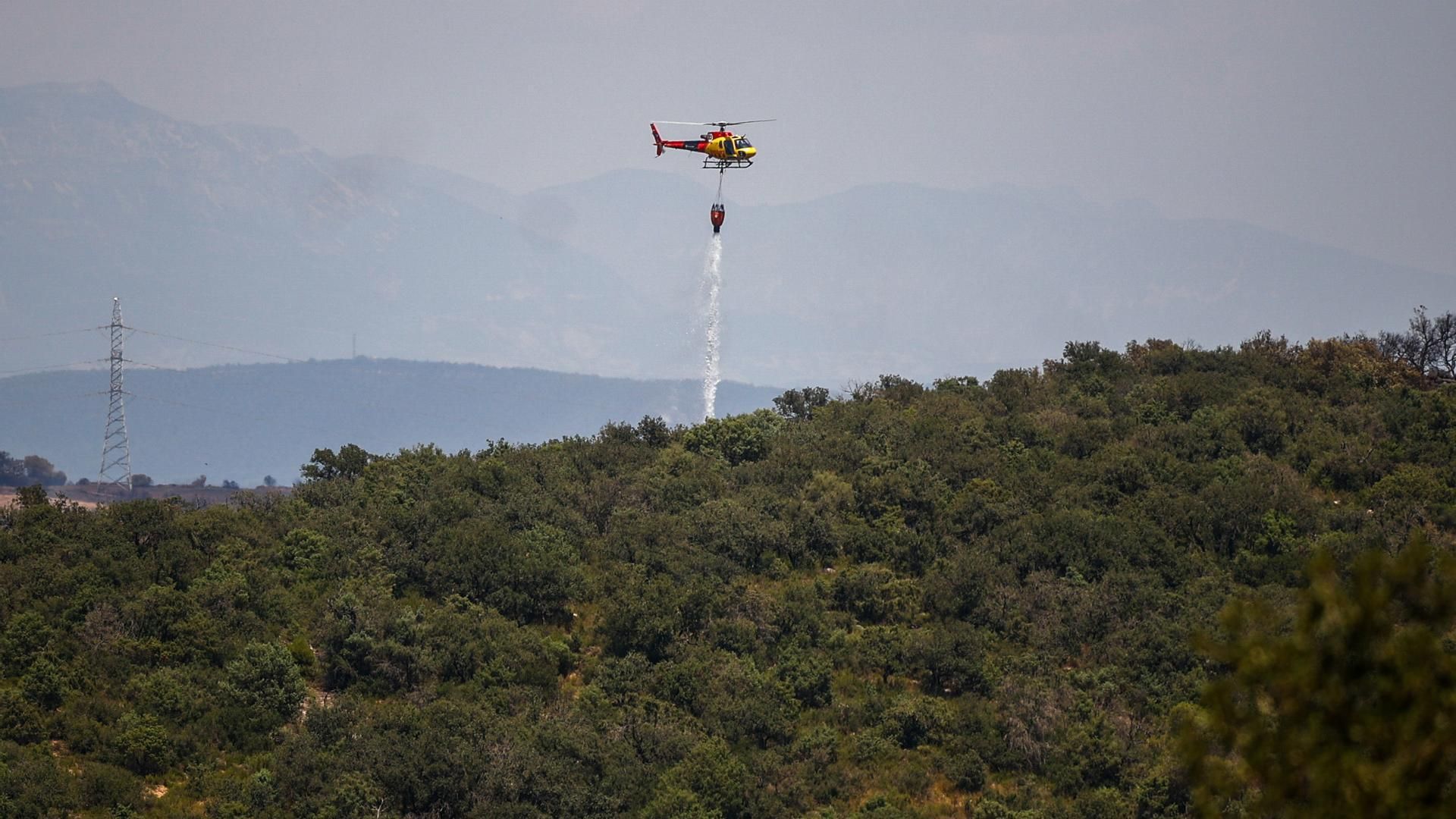 Helicópteros de bomberos tratan de apagar los restos del incendio en Torrefeta i Florejacs (Lleida)