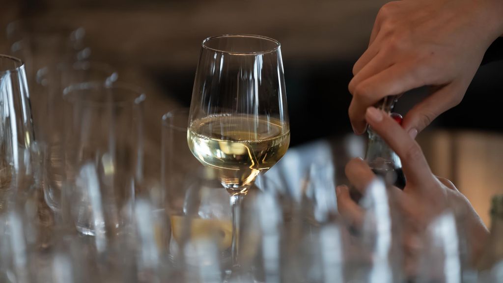 Un camarero sirve una consumición en la barra de un local
