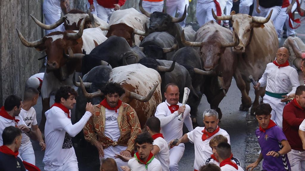 Mozos perseguidos por los toros de la ganadería de José Escolar en el sexto encierro de los Sanfermines