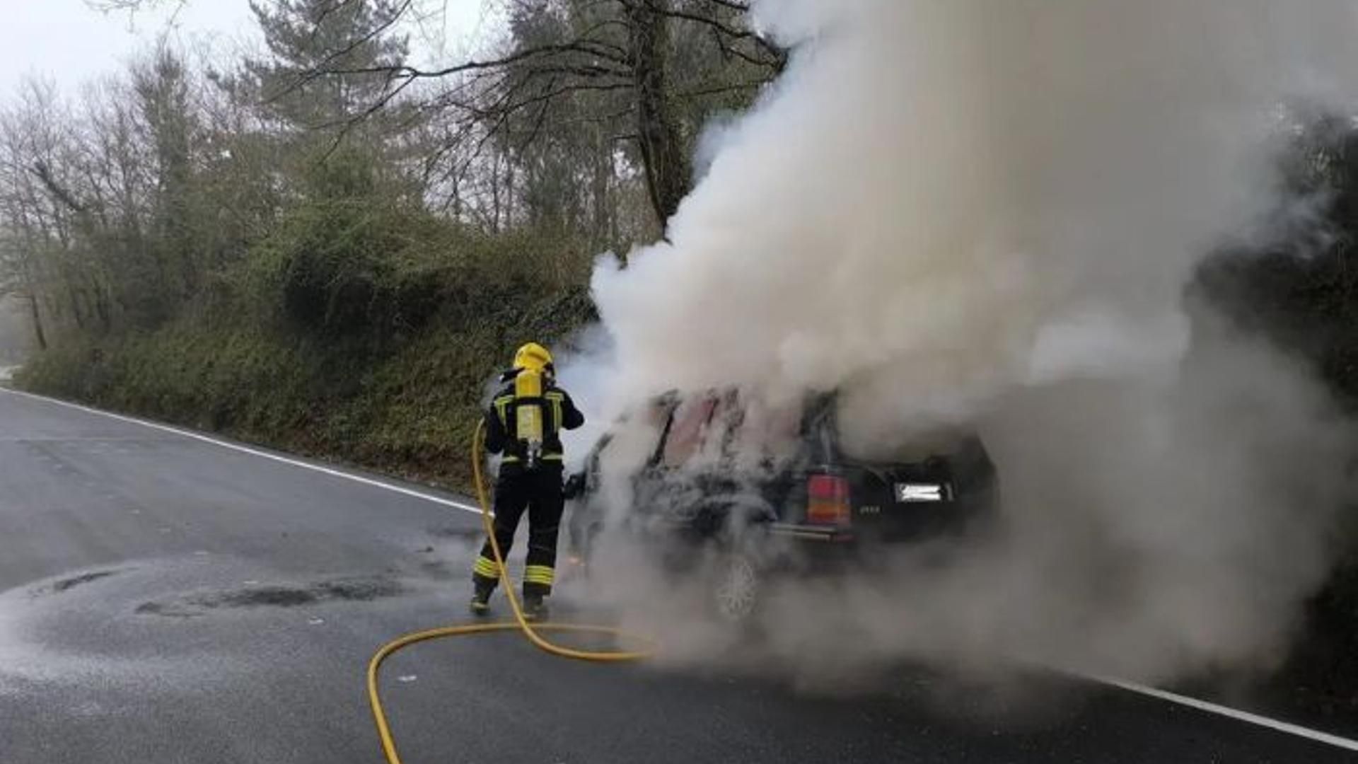 Bombero apagando el incendio en un coche
