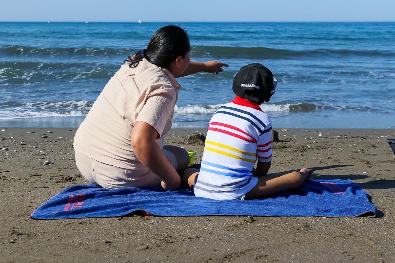 El pequeño junto a su madre en la playa de El Palo