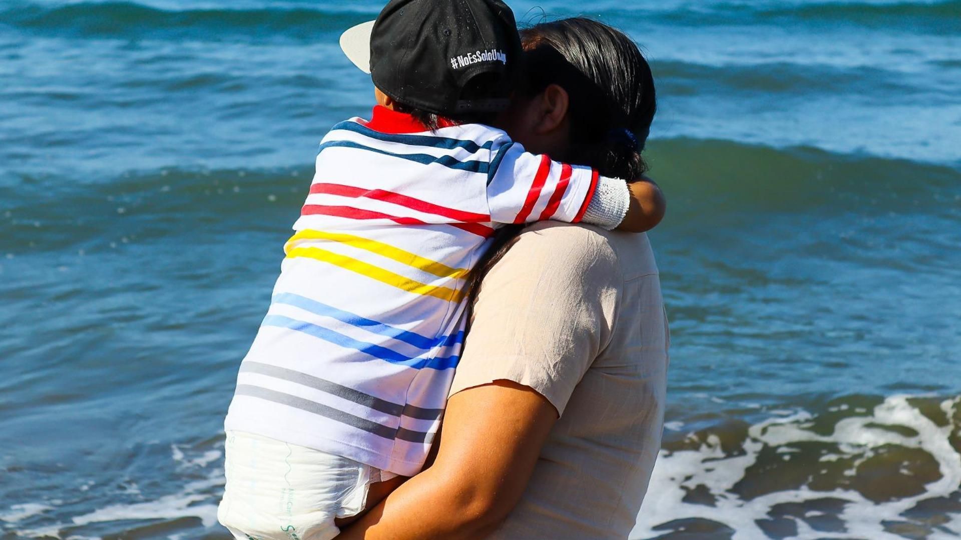 El pequeño contempla el mar junto a su madre en una playa de El Palo, Málaga