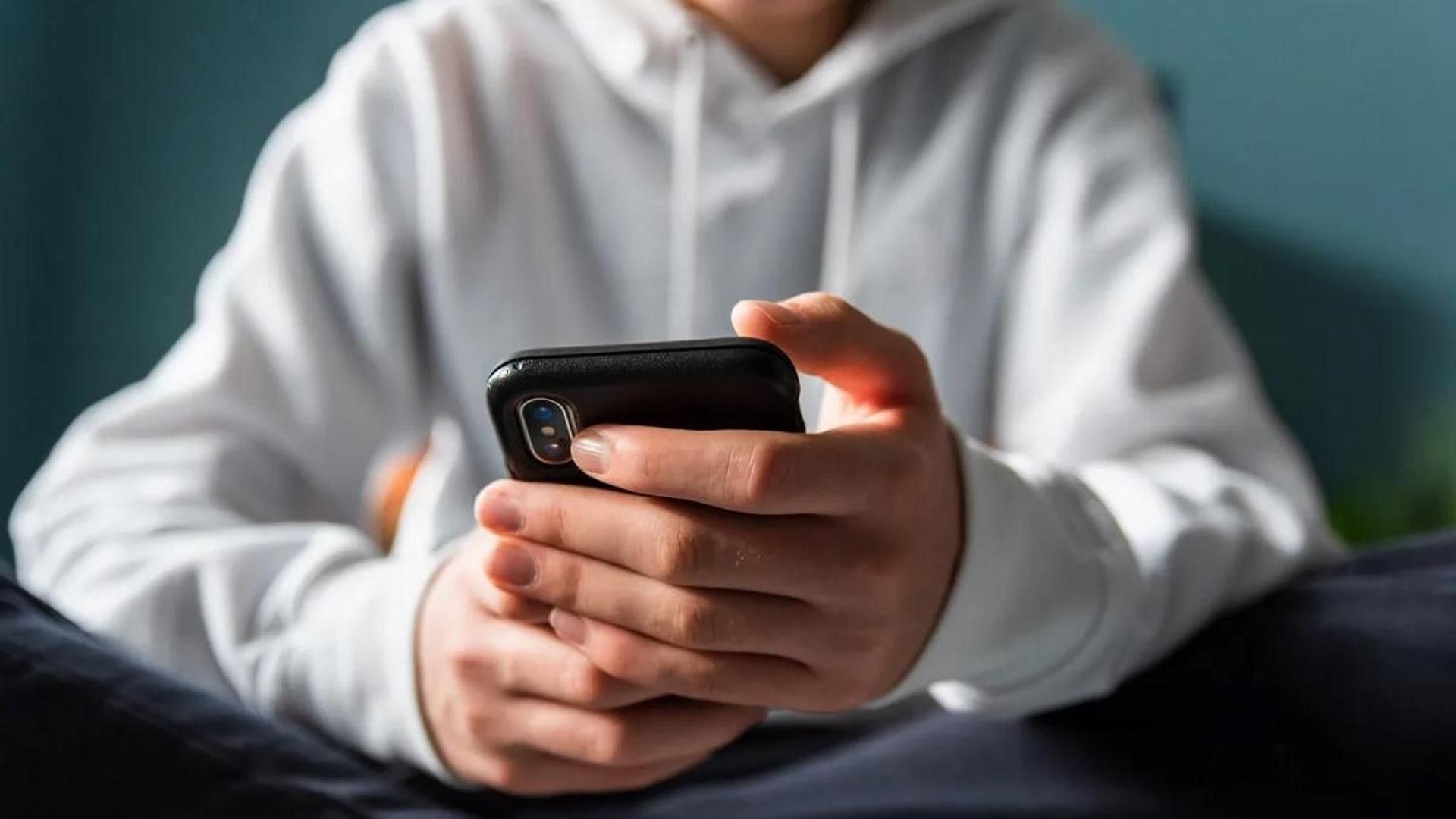 Adolescente pendiente del móvil