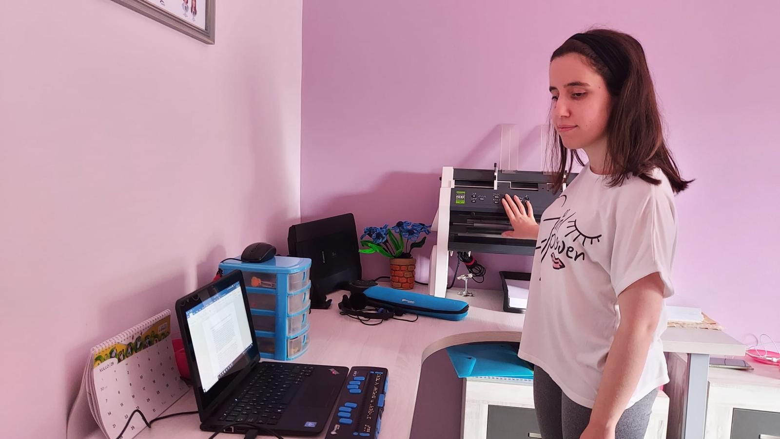 Lucía con la impresora Braille y el teclado Braille adaptado a su ordenador