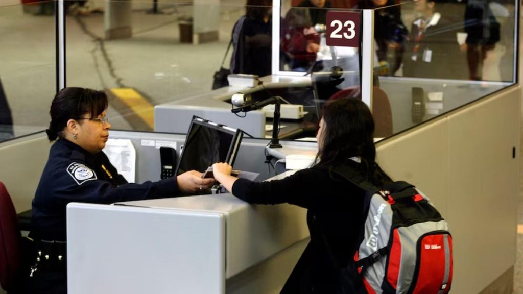 Una empleada revisa el visado a una pasajera en un aeropuerto de EEUU.