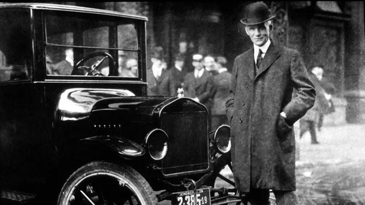 Henry Ford ante uno de sus coches