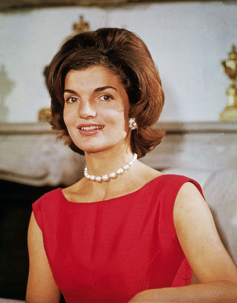 Jackie Kennedy, todo un icono de estilo con un vestido rojo y collar de perlas en 1960