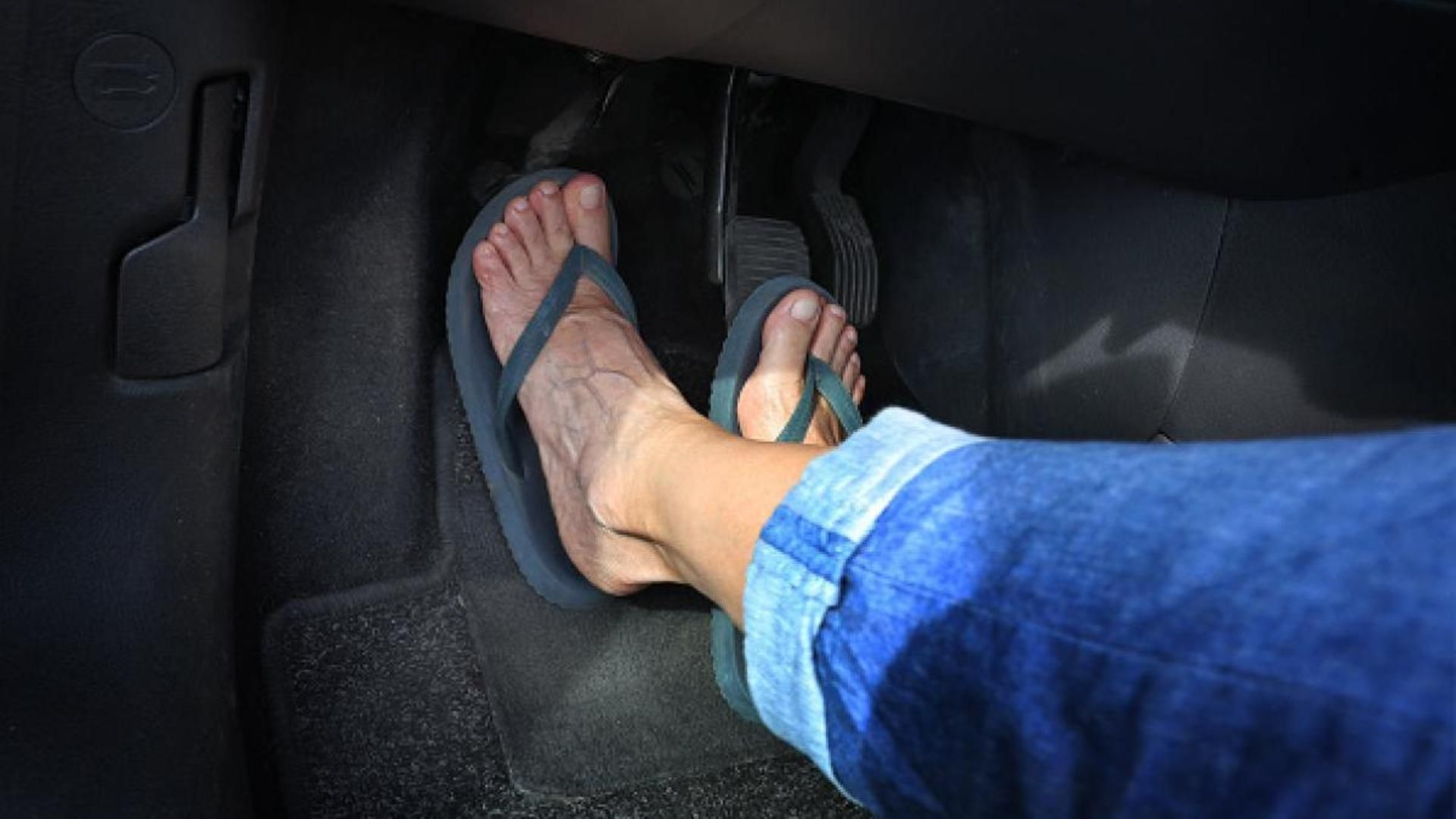 Una persona conduciendo con chanclas