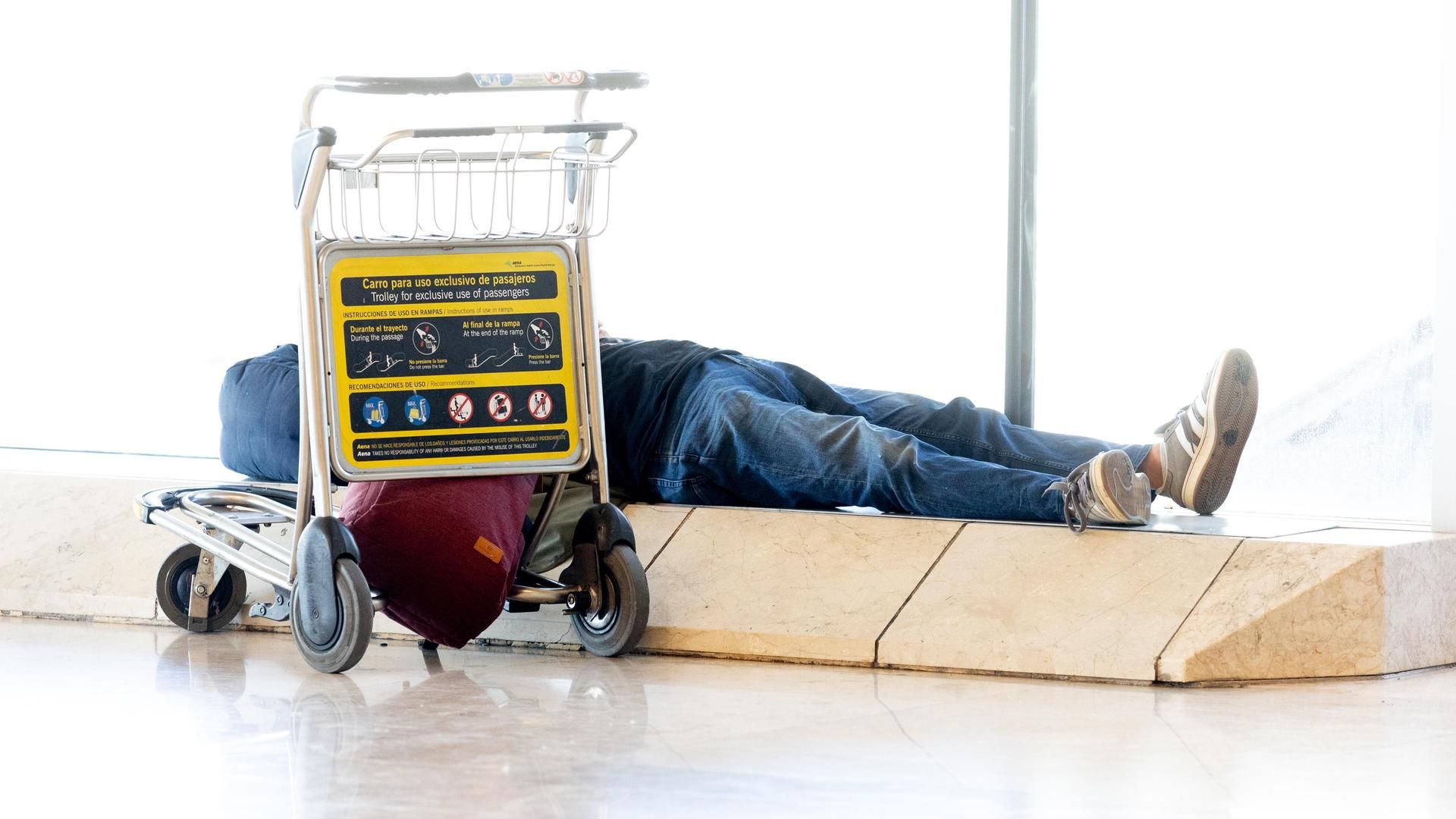 Una persona tumbada en la T4 del Aeropuerto Adolfo Suárez Madrid-Barajas
