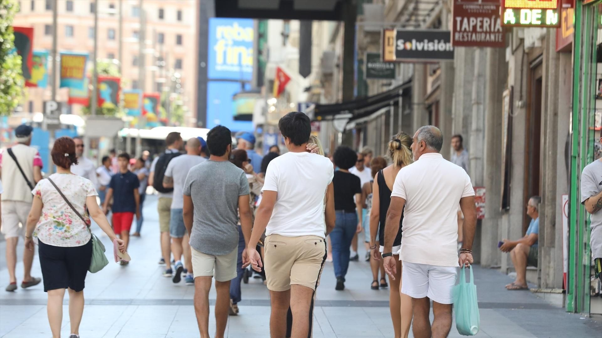Un grupo de personas pasean por una calle de Madrid.