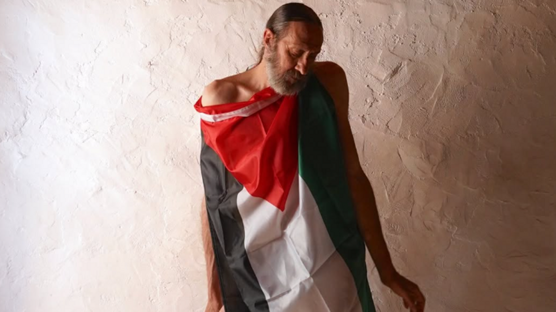 El diseñador Miguel Adrover vistiendo una bandera de Palestina para sus redes sociales