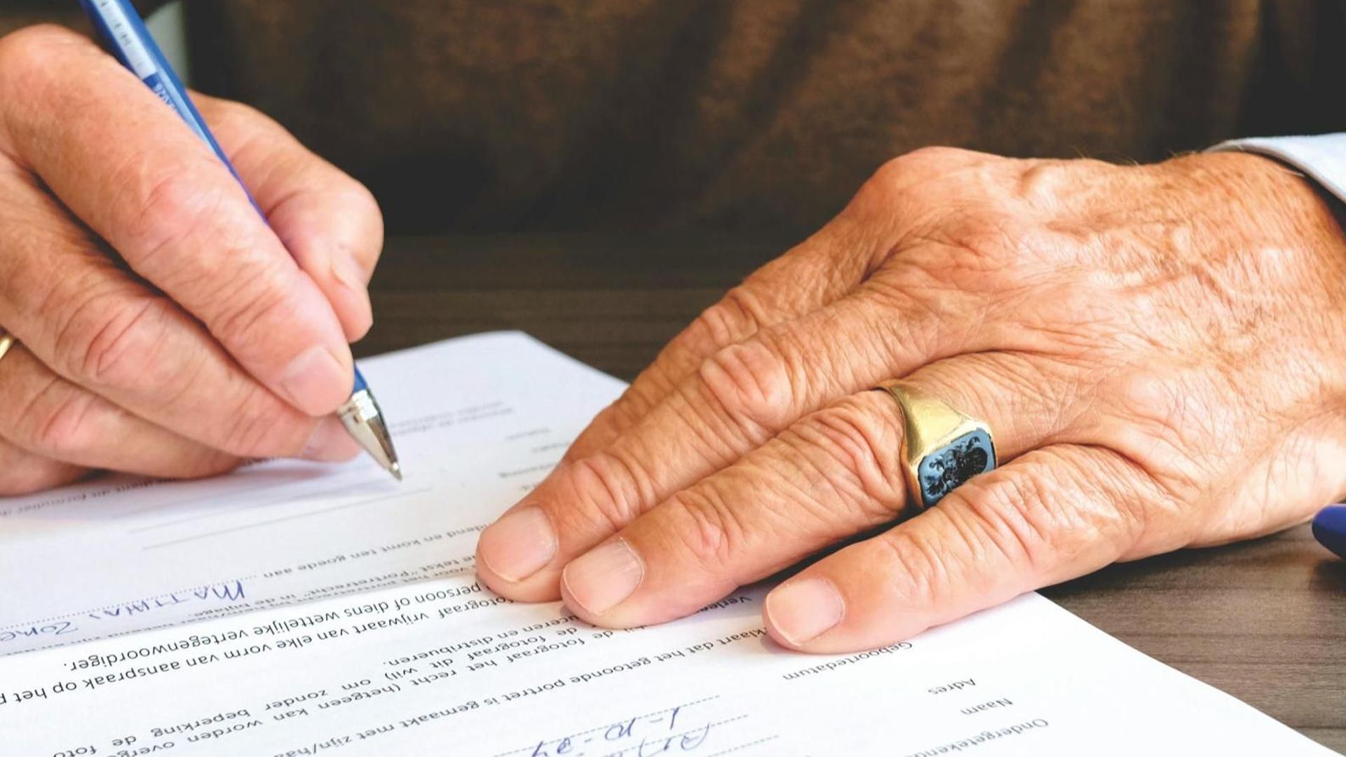 Un hombre firmando un documento