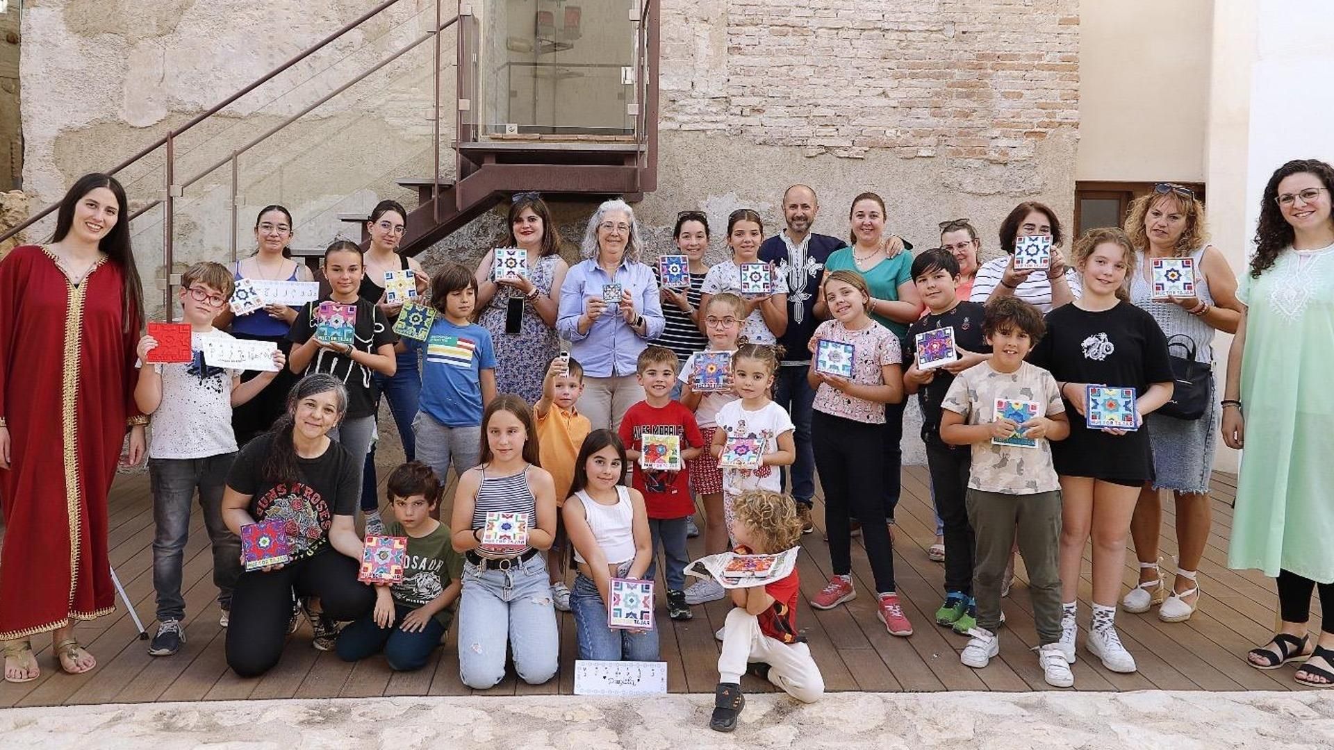 Niños que han decorado cajas de madera con la técnica de la taracea