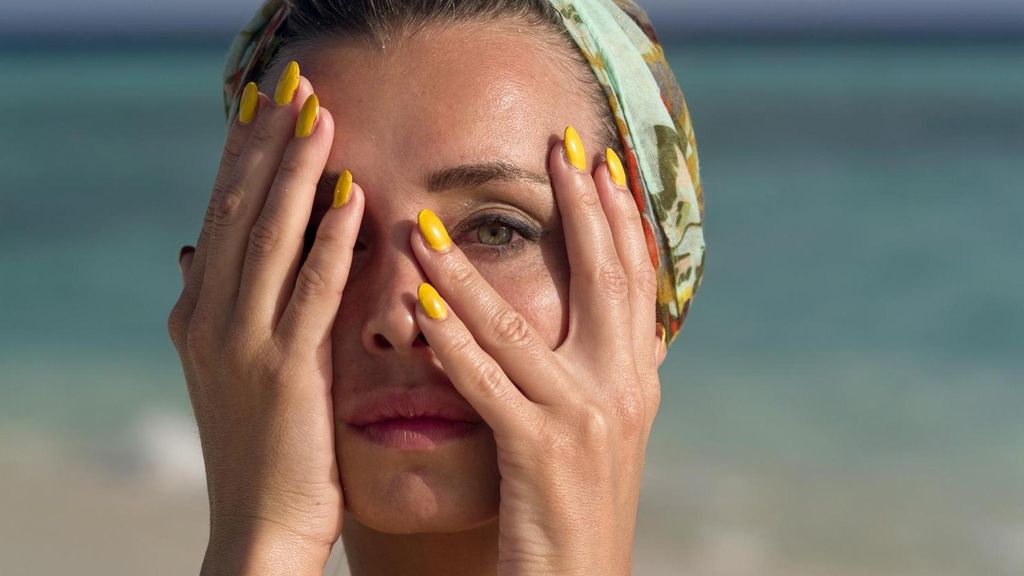 Una muejr con uñas amarillas en la playa