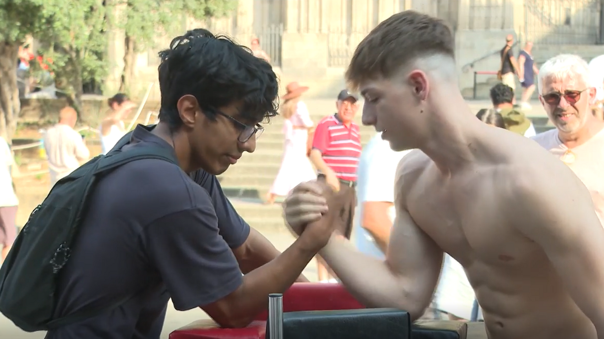 Joel, el joven que pone a prueba la fuerza de los transeúntes con un pulso en las calles de Barcelona