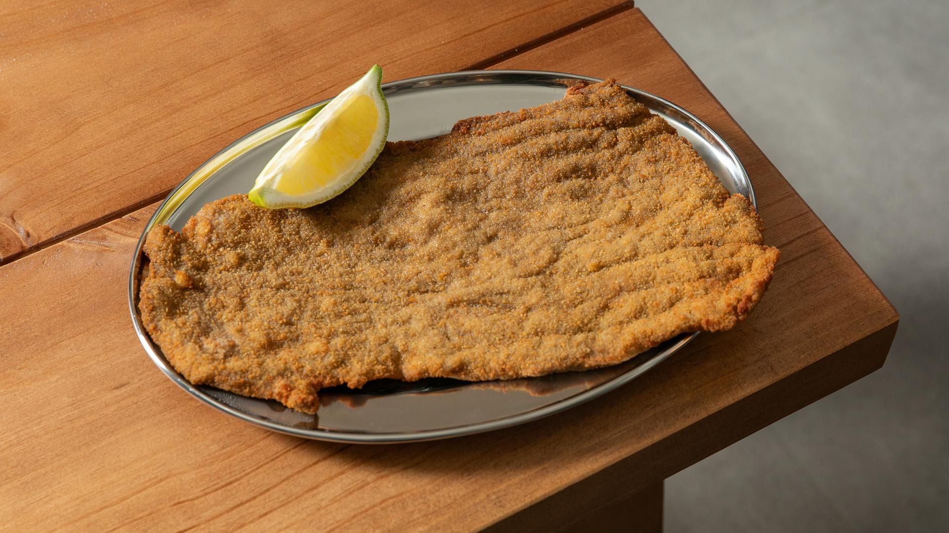 Una milanesa clásica con su trozo de limón, como mandan los cánones