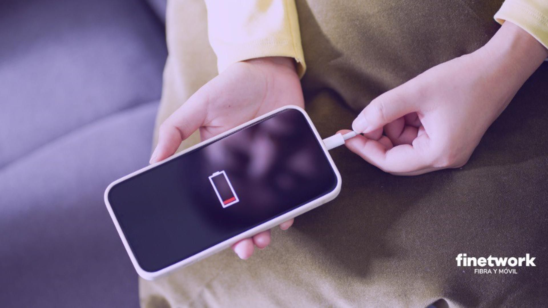 Persona cargando un smartphone con la batería gastada