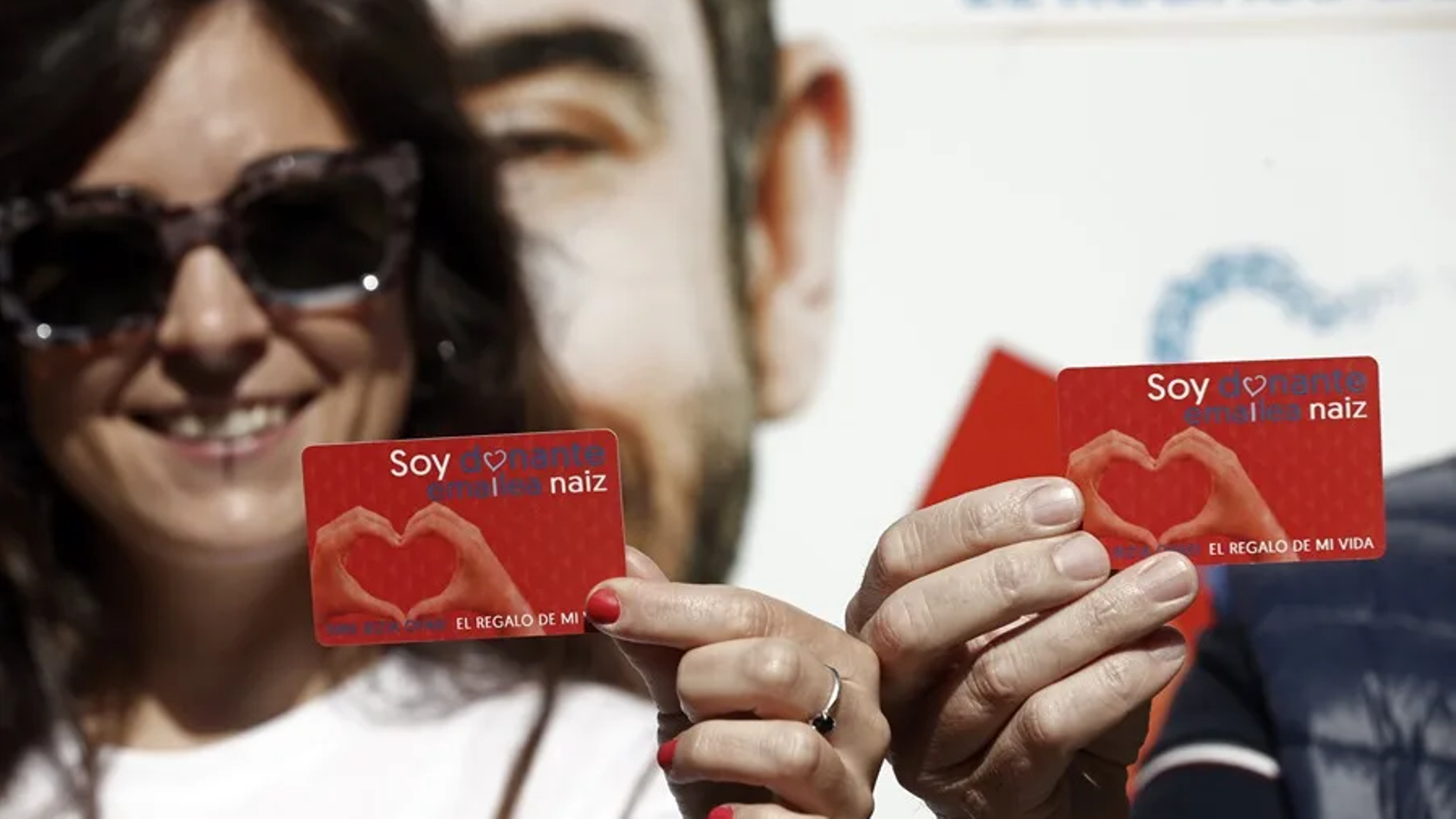 Dos personas muestran su carnet de donantes de órganos