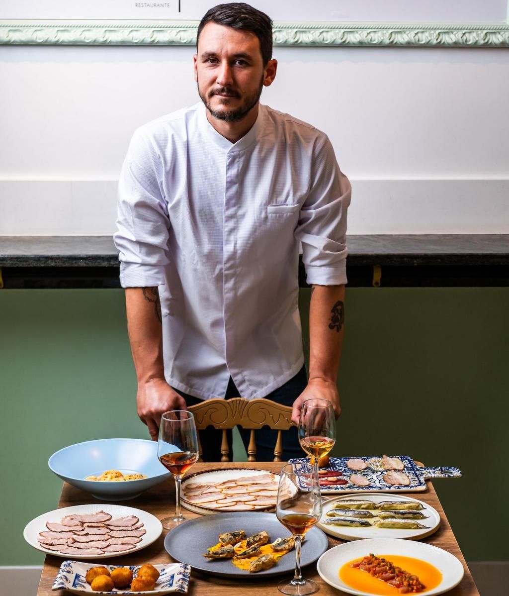 Ricardo Romero posando en la zona de barra de Menudeo con otros de sus platos más demandados