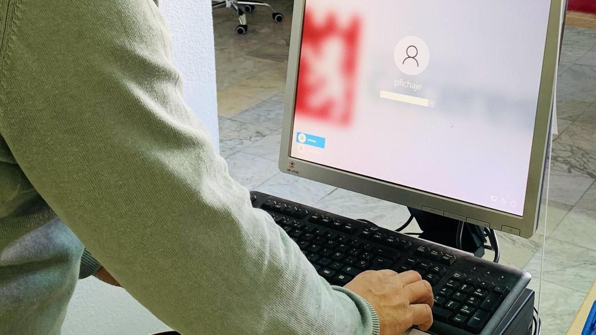 Un trabajador ficha su entrada a trabajar en una dependencia municipal