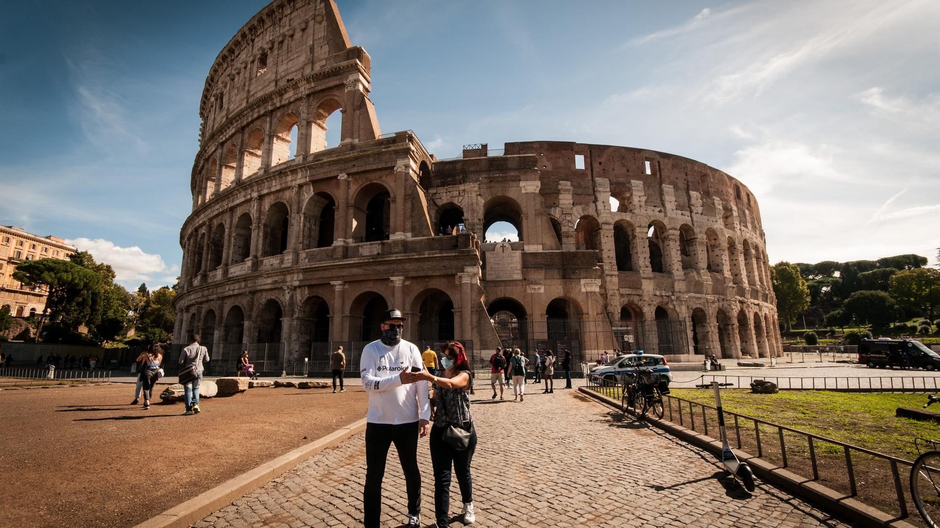 Turistas pasean en las inmediaciones del Coliseo de Roma, Italia