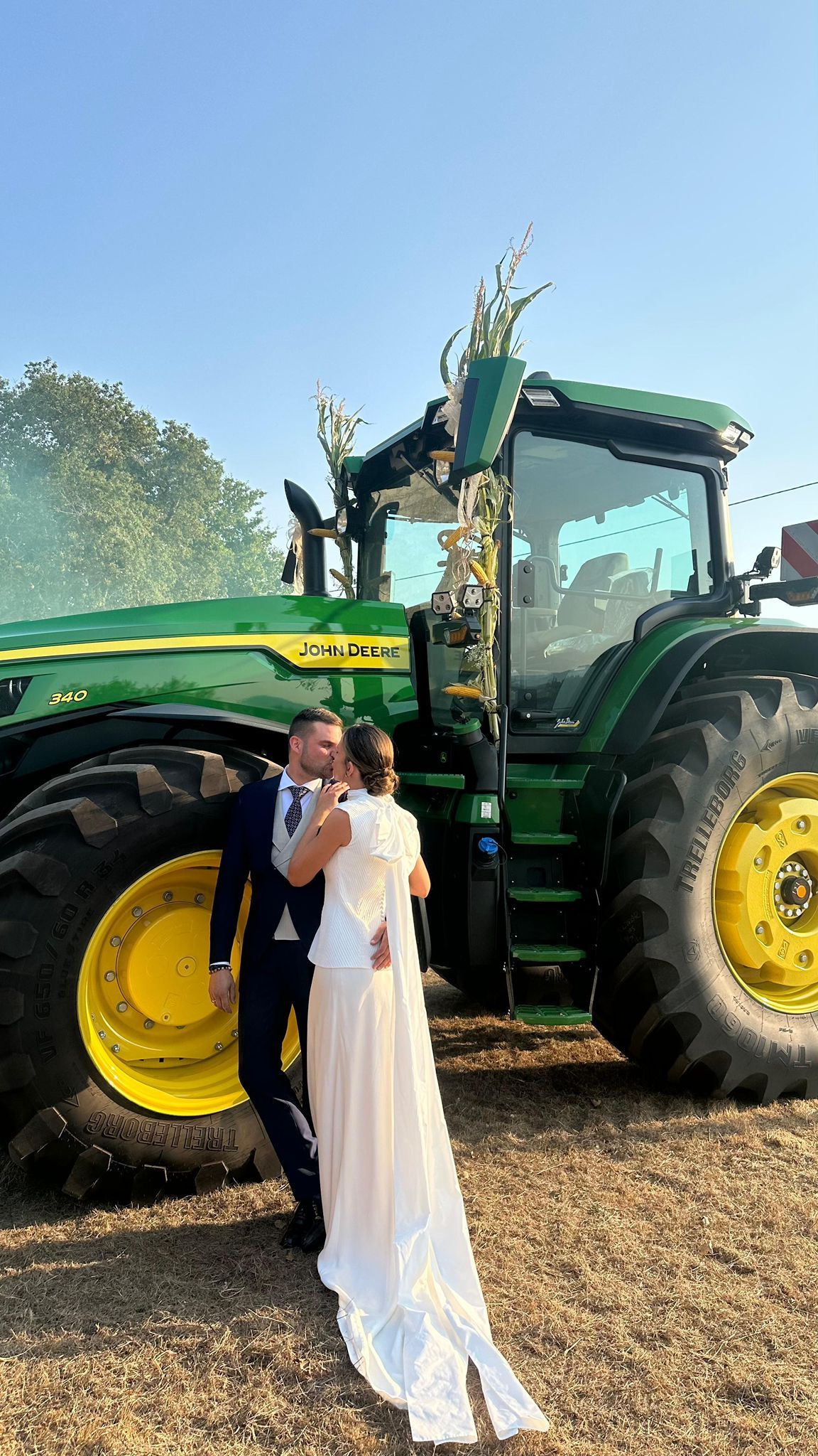 Carlota y Álex posando ante el imponente tractor