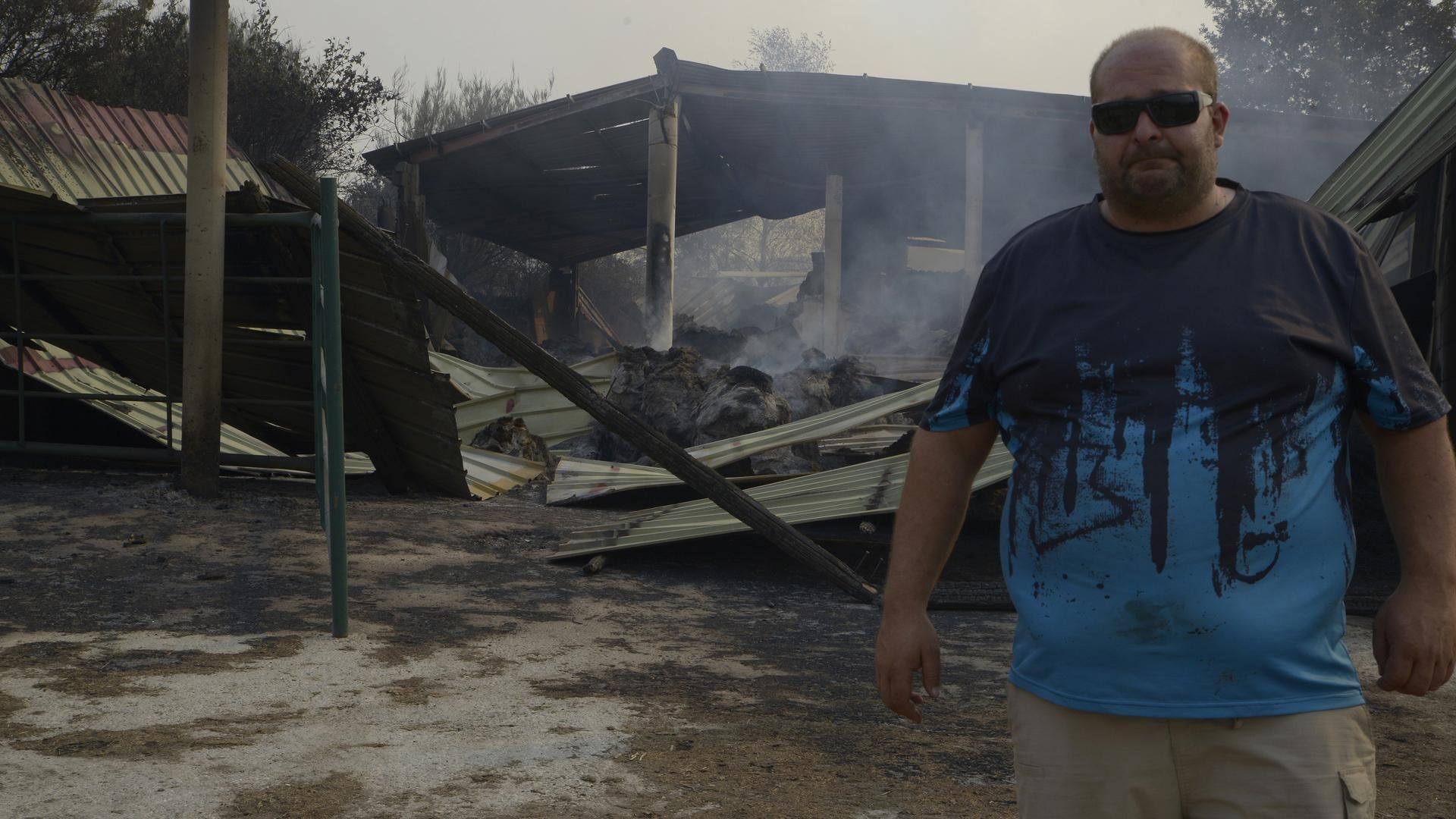 Un ganadero observa el estado de su granja tras el paso del fuego en Cova, Pobra de Trives, Ourense, Galicia (España).